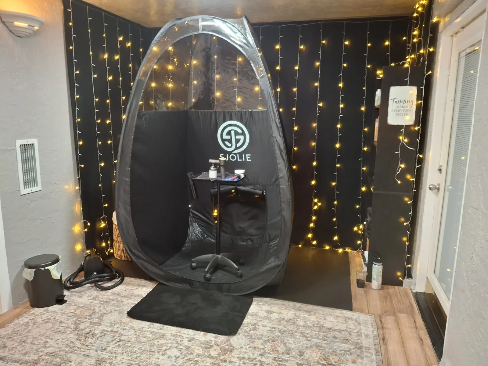 Private spray tanning booth with warm string lights